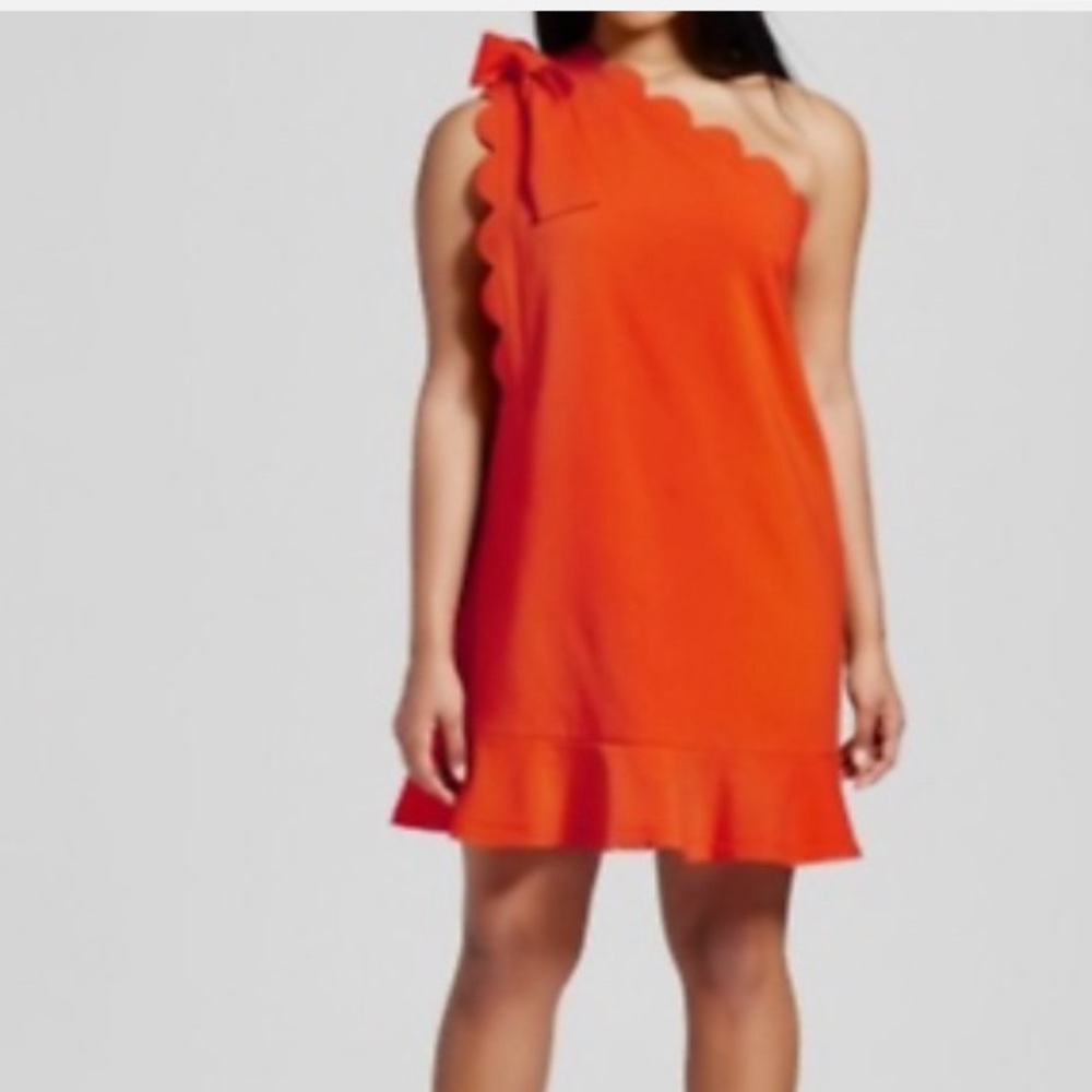 Victoria Beckham one shoulder orange mini dress with scalloped edges.